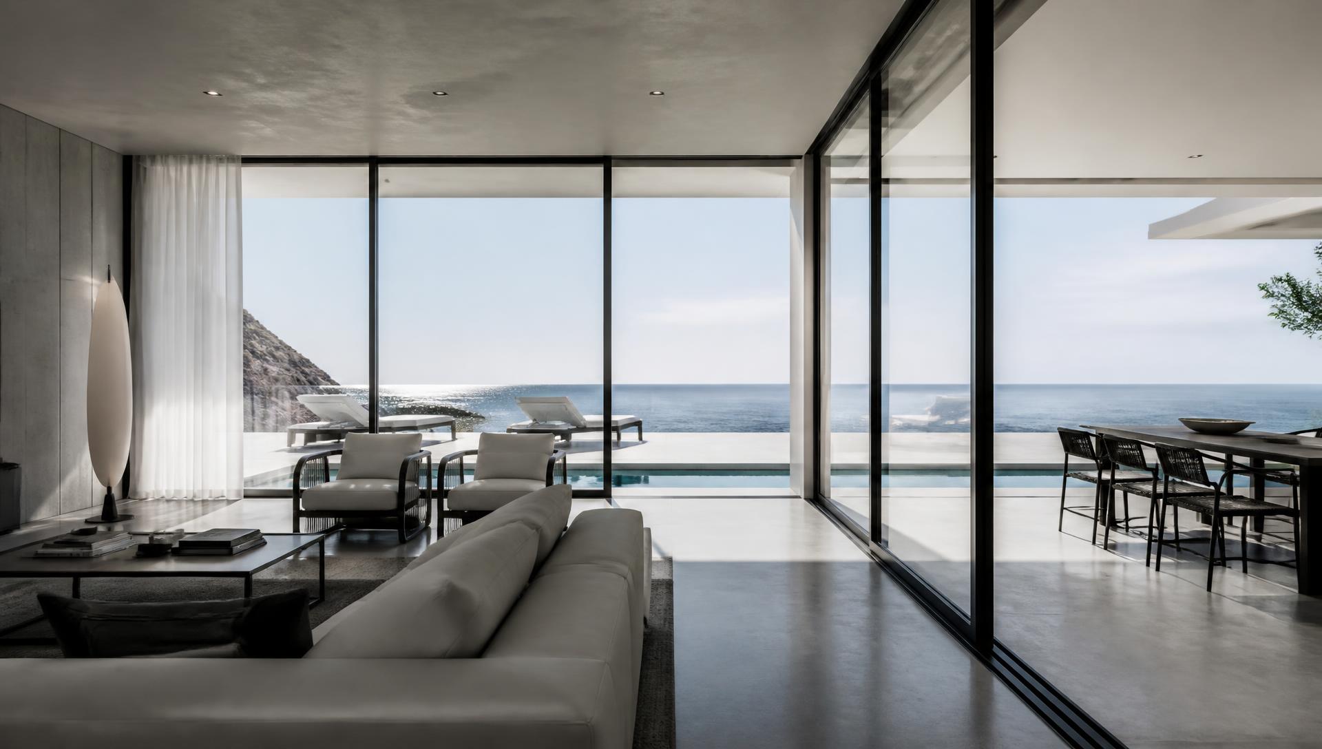 Minimalist villa interior with slim aluminium framed glass walls overlooking the sea